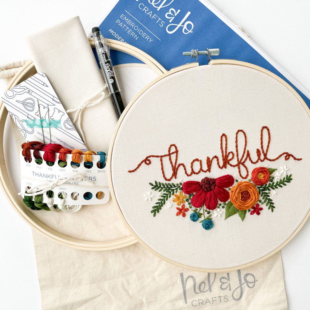 Thankful flowers hoop has flowers under the word Thankful. Also shown are kit supplies. 