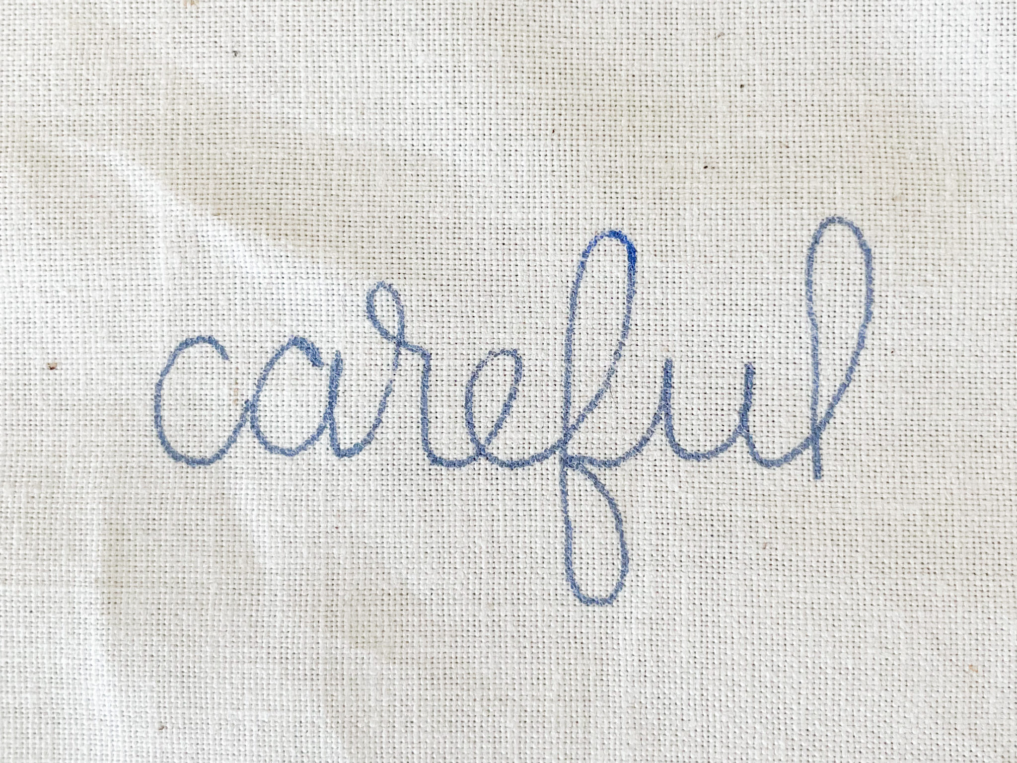 The word "careful" written on fabric. Showing what a good pattern transfer should look like. 