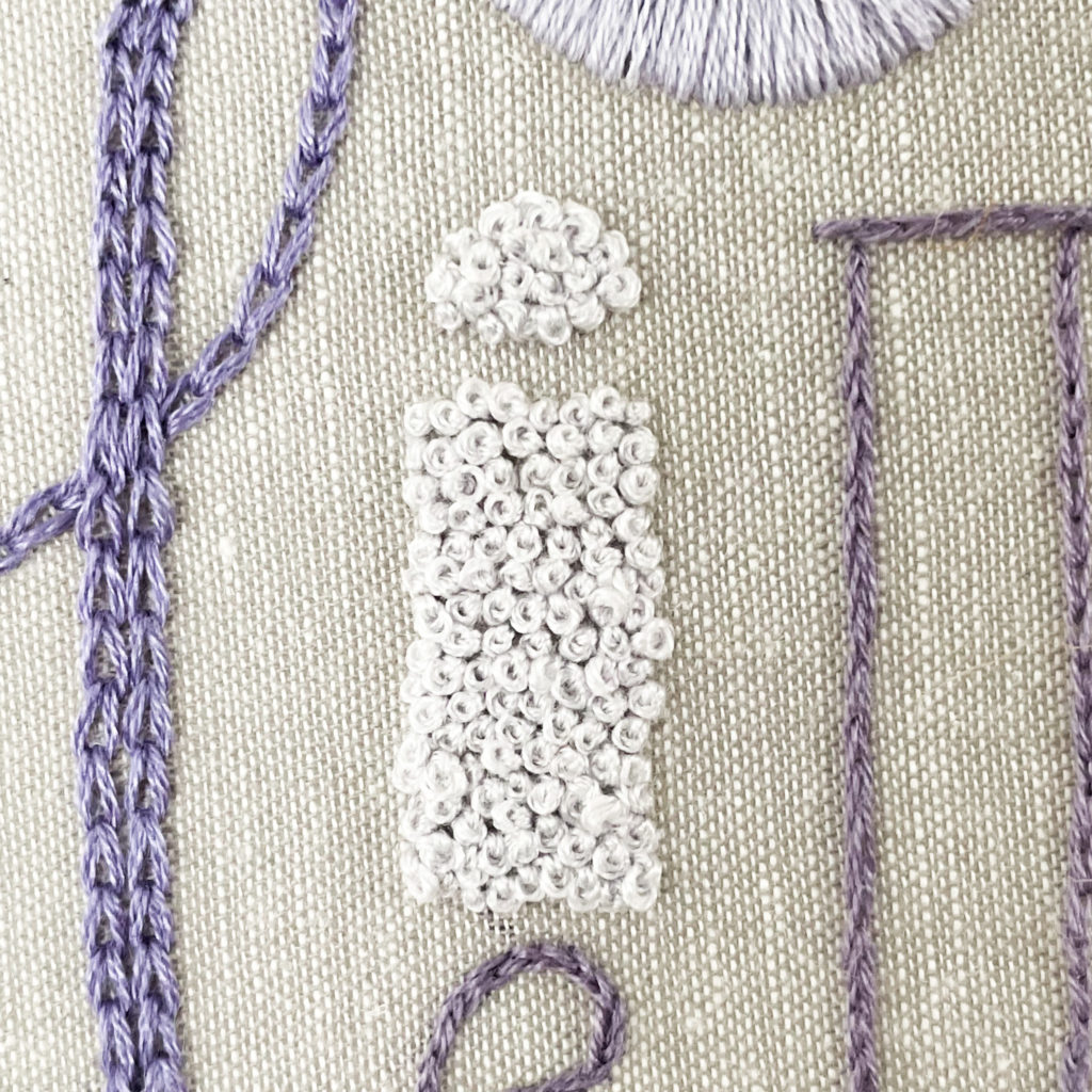 The letter "i" filled with French knots.