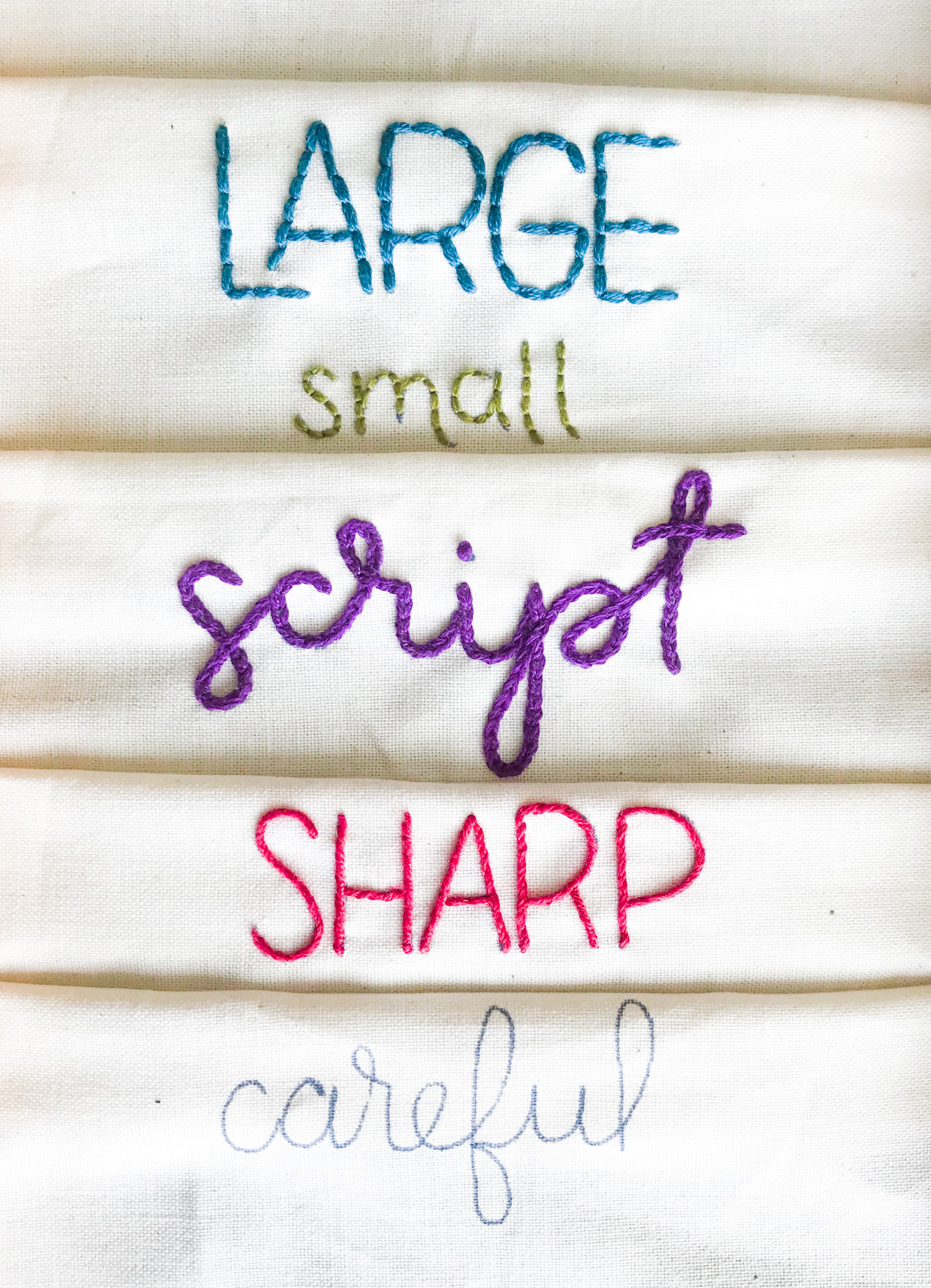 The words "Large, small, script, sharp, and carful" stitched in different styles.