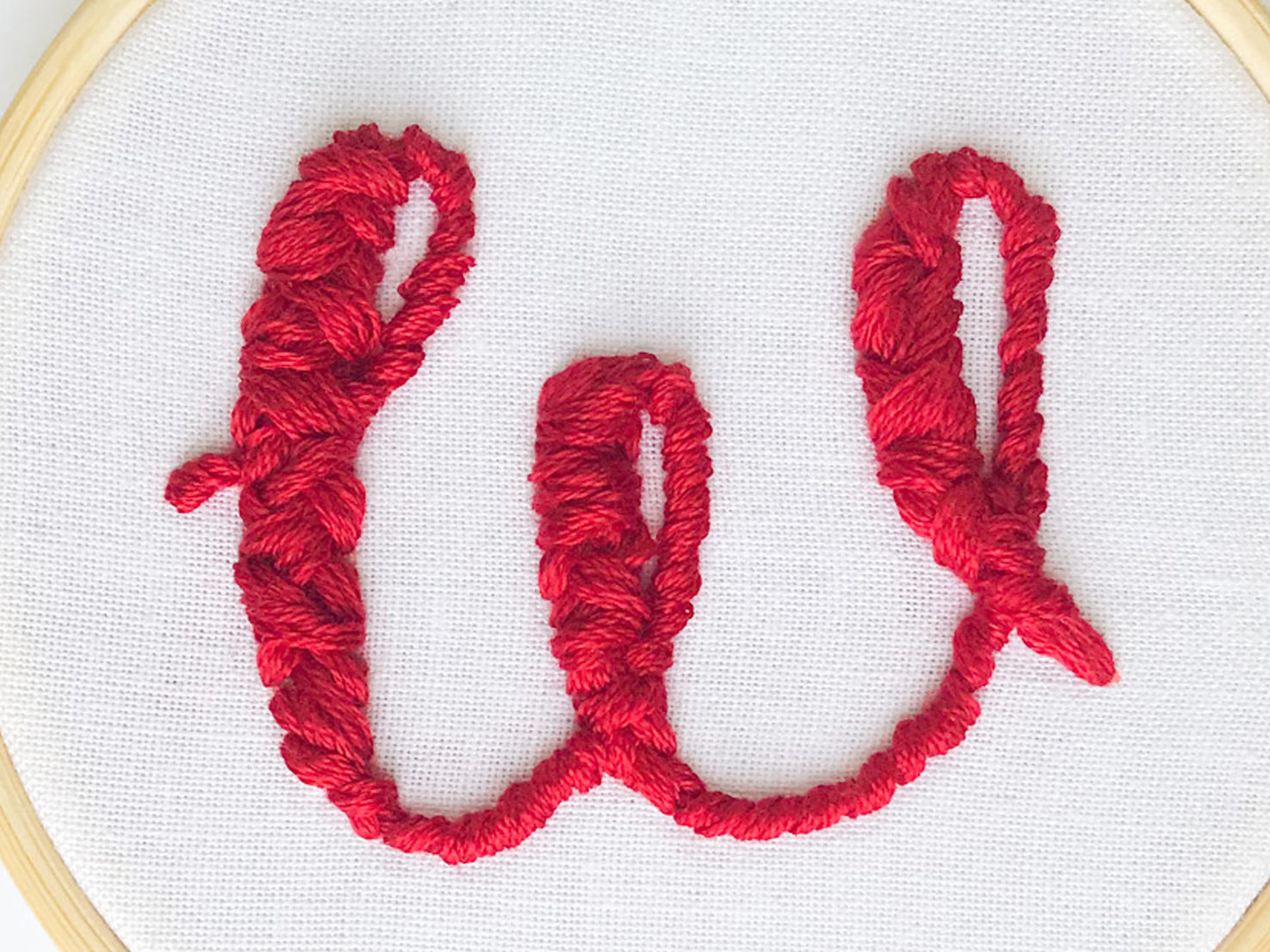 The letter "w" filled with a puff stitch. 